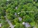 This aerial view shows the home's location on Lansford Road among lush greenery at 8227 Lansford Rd, Charlotte, NC 28277