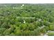 Aerial view of property surrounded by lush green trees with Ballantyne in the background at 8227 Lansford Rd, Charlotte, NC 28277