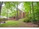 A spacious backyard with mature trees, lawn, and brick home with back deck at 8227 Lansford Rd, Charlotte, NC 28277