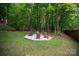 Secluded backyard retreat with a fire pit, hammock, and lush greenery perfect for outdoor relaxation at 8227 Lansford Rd, Charlotte, NC 28277