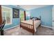 Cozy bedroom with blue walls, a plush bed, and natural light from two windows at 8227 Lansford Rd, Charlotte, NC 28277