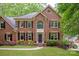Beautiful two-story brick home with lush landscaping and a welcoming entrance in a wooded setting at 8227 Lansford Rd, Charlotte, NC 28277