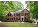 Stately two-story brick home with manicured lawn and mature trees offers timeless elegance at 8227 Lansford Rd, Charlotte, NC 28277