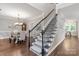Elegant staircase with decorative ironwork leading to a dining room with hardwood floors at 8227 Lansford Rd, Charlotte, NC 28277