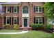 Charming brick home entrance showcases a classic black door and well-maintained landscaping at 8227 Lansford Rd, Charlotte, NC 28277