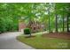 Charming brick two-story home with a manicured lawn and mature trees at 8227 Lansford Rd, Charlotte, NC 28277