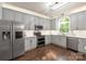 Bright kitchen with gray cabinets, stainless steel appliances, and a hardwood flooring at 8227 Lansford Rd, Charlotte, NC 28277