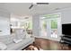 Open-concept living room with a sofa, fireplace, and French doors leading to an outdoor deck with wooded views at 8227 Lansford Rd, Charlotte, NC 28277