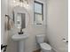 Stylish powder room with a pedestal sink, modern lighting, and a round mirror at 8723 Nolley Ct, Charlotte, NC 28270