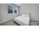 Serene bedroom with natural light, plush carpet, and a comfortable queen-size bed with white linens at 8723 Nolley Ct, Charlotte, NC 28270
