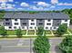 Modern townhomes with monochromatic color scheme complemented by lush green trees and manicured lawns at 8723 Nolley Ct, Charlotte, NC 28270