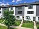 Modern townhome exterior with gray and white siding, black trim, and a well-manicured front lawn and landscaping at 8723 Nolley Ct, Charlotte, NC 28270