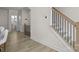 Hallway with view to powder room and black and wood staircase at 8723 Nolley Ct, Charlotte, NC 28270