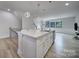 Kitchen island with white countertop, gold pendant lights, and stainless steel appliances at 8723 Nolley Ct, Charlotte, NC 28270