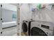 Well-equipped laundry room with washer, dryer, and ample shelving at 8723 Nolley Ct, Charlotte, NC 28270