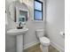 Stylish powder room with a pedestal sink, modern faucet, and neutral decor at 8723 Nolley Ct, Charlotte, NC 28270