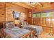Inviting bedroom featuring two twin beds, wood-paneled walls, and a window with natural light at 9289 Azalea Rd, Sherrills Ford, NC 28673