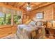 Cozy bedroom with wood walls, patterned quilt, and natural light from the window, creating a relaxing retreat at 9289 Azalea Rd, Sherrills Ford, NC 28673