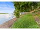 Lakeside property featuring lush green grass leading down to the water and boathouse at 9289 Azalea Rd, Sherrills Ford, NC 28673