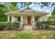 Charming home with a welcoming front porch, mature landscaping, and a well-maintained lawn at 1000 Oakshade Ave, Kannapolis, NC 28083
