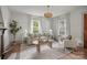 Bright living room featuring neutral tones, a decorative chandelier, and large windows at 1000 Oakshade Ave, Kannapolis, NC 28083