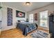 A cozy bedroom features a bed with a black comforter, hardwood floors, a basketball hoop, and natural light at 1140 Landsdown Dr, Salisbury, NC 28147