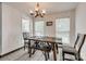 Dining room features a wooden table and bench, modern chandelier, and bright window views at 1140 Landsdown Dr, Salisbury, NC 28147