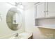 Well-lit bathroom featuring vanity, round mirror and cabinet at 1215 Green Oaks Ln # H, Charlotte, NC 28205