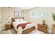 The bedroom features a wood frame bed with white linens, side tables, and a large window at 1215 Green Oaks Ln # H, Charlotte, NC 28205