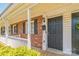 Charming brick home featuring a covered front porch, black door and shutters, with a neatly landscaped yard at 1215 Green Oaks Ln # H, Charlotte, NC 28205