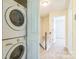 Hallway with stacked washer and dryer with a stairway in the background at 1215 Green Oaks Ln # H, Charlotte, NC 28205