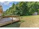 Expansive backyard featuring a wooden deck, lush green grass, mature trees and a fire pit perfect for outdoor enjoyment at 1221 Woodpecker Dr, Clover, SC 29710
