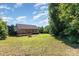 Spacious backyard featuring a wooden deck, fire pit, and mature trees, perfect for outdoor entertaining at 1221 Woodpecker Dr, Clover, SC 29710