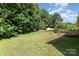 Large backyard featuring lush greenery, mature trees, a wooden deck, and ample space for outdoor activities and relaxation at 1221 Woodpecker Dr, Clover, SC 29710