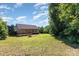 Expansive backyard view of the home featuring a deck, fire pit, ample green space, and mature trees offering privacy at 1221 Woodpecker Dr, Clover, SC 29710