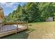 Expansive backyard featuring a wooden deck, lush green grass, mature trees and a fire pit perfect for outdoor enjoyment at 1221 Woodpecker Dr, Clover, SC 29710