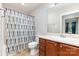 Well-maintained bathroom featuring a vanity with wooden cabinets, a large mirror, and a shower with a patterned curtain at 1221 Woodpecker Dr, Clover, SC 29710