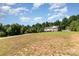 A long shot of a home nestled in a spacious, wooded lot with a long driveway at 1221 Woodpecker Dr, Clover, SC 29710