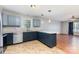 Well-lit kitchen with stainless steel appliances, blue cabinets, and a window overlooking the front yard at 1221 Woodpecker Dr, Clover, SC 29710
