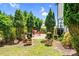 Backyard view showcasing a patio area with outdoor seating nestled among mature trees and manicured greenery at 13204 Feale Ct, Charlotte, NC 28278