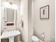 Well-lit powder room featuring a pedestal sink, framed art, and neutral wall color at 13204 Feale Ct, Charlotte, NC 28278