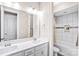 Bathroom featuring double sinks, white cabinets, and tiled bathtub with shower at 13204 Feale Ct, Charlotte, NC 28278