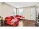 Comfortable bonus room with a red sectional, hardwood floors, and natural light from the windows at 13204 Feale Ct, Charlotte, NC 28278