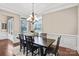 Formal dining room with chandelier, large window with modern blinds, and dark wood table at 13204 Feale Ct, Charlotte, NC 28278