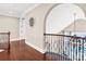 Elegant hallway with dark wood floors and wrought iron railing overlooking the living space below at 13204 Feale Ct, Charlotte, NC 28278