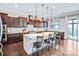 Elegant kitchen featuring dark wood cabinetry, a large island, and modern lighting fixtures at 13204 Feale Ct, Charlotte, NC 28278