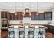 This expansive kitchen island features pendant lights, barstool seating and a cooktop at 13204 Feale Ct, Charlotte, NC 28278