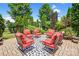 Inviting patio with red cushioned seating and a stylish black and white patterned outdoor rug, surrounded by lush landscaping at 13204 Feale Ct, Charlotte, NC 28278