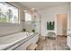 Bright bathroom with a soaking tub under a large window and a glass enclosed shower at 155 Boxelder Rd, Clover, SC 29710