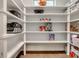 Spacious walk-in pantry with white shelving and beautiful wood flooring offers plenty of storage space at 155 Boxelder Rd, Clover, SC 29710